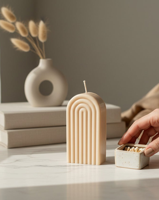 Luxora Candles Arcus decorative candle in a beige, arched, fluted design. Modern, minimalist, sculptural style.