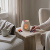 Arzător ceramic Luxora aprins, cu wax melts topindu-se și parfumând camera