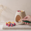 Aprinderea unei lumânări tip pastilă sub arzătorul ceramic oval crem Luxora