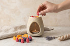 Wax melts Noir colecția Nectar, căpșuni și afine lângă arzătorul ceramic Luxora