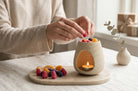 Wax melts Velvet colecția Nectar, căpșuni și felii de portocală lângă arzătorul ceramic crem